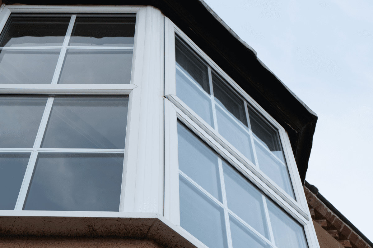 White-framed bay window with blue sky.